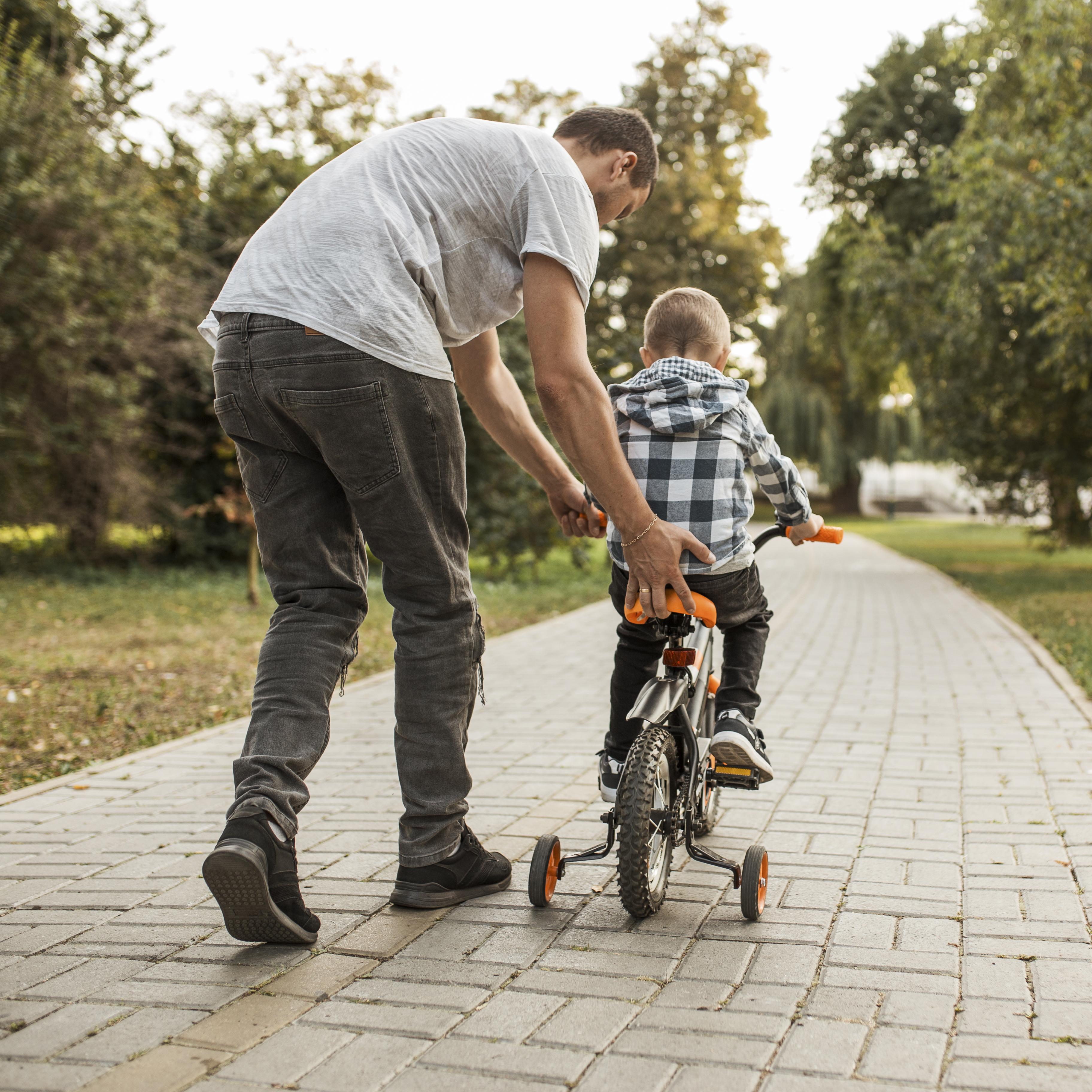 Pai ensinando filho a andar de bicicleta